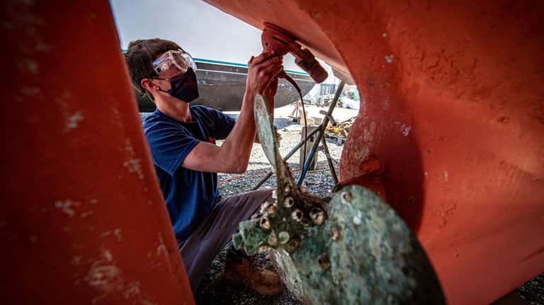 Casey Malone works on his uncle Doug Shaw's boat at...