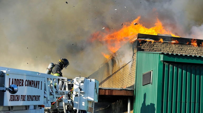 Firefighters battle a large fire Wednesday afternoon at a commercial building...