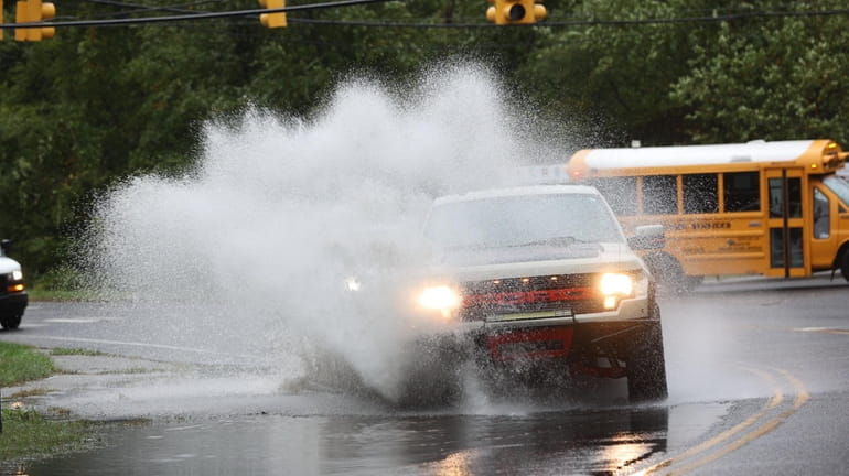 A vehicle navigates through a large puddle on Mill Road...