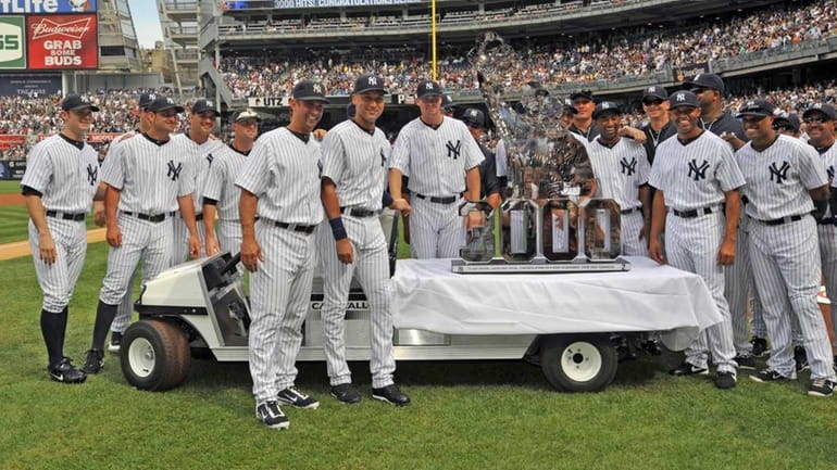 Derek Jeter and his teammates pose with the special sculpture...