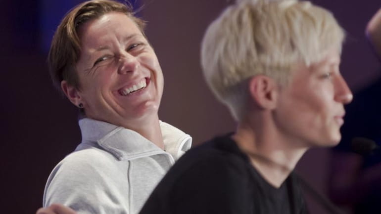 United States women's soccer player Abby Wambach, left, laughs as...