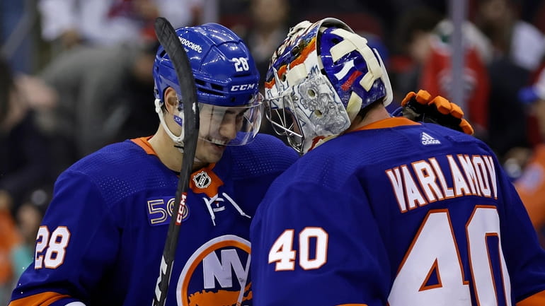 Islanders goaltender Semyon Varlamov celebrates with Alexander Romanov (28) after...