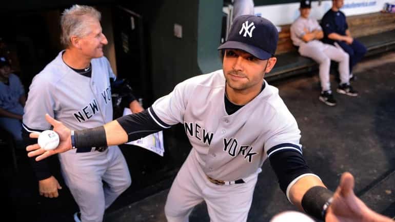 Nick Swisher catches baseballs to sign before a game against...