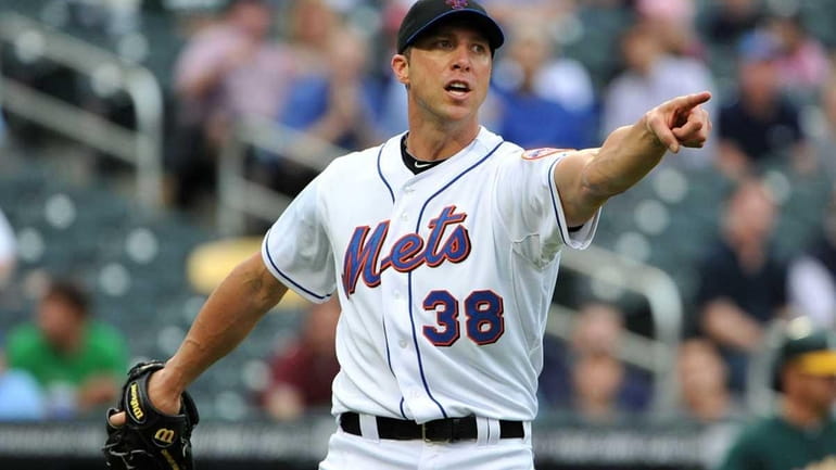 Mets starting pitcher Chris Capuano points in the direction of...