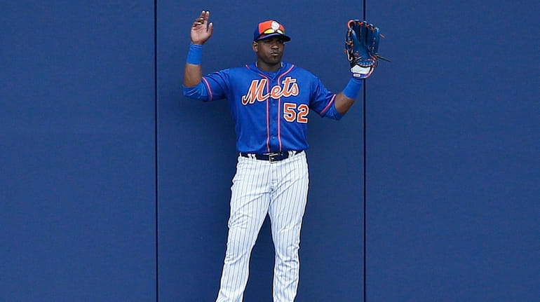 Mets centerfielder Yoenis Cespedes holds up his hands thinking a...