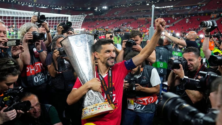 Sevilla's Jesus Navas carries the trophy after winning the Europa...