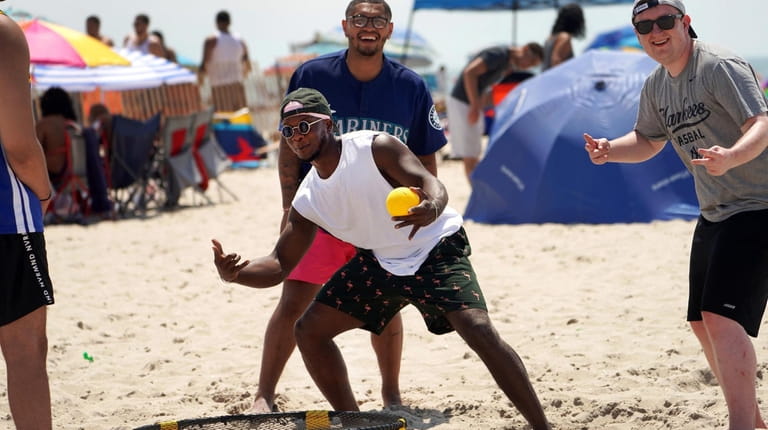 Andre Bennett of Central Islip, center, plays Spikeball with friends...