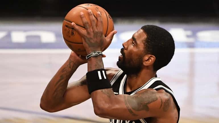Nets guard Kyrie Irving shoots a free throw against the...