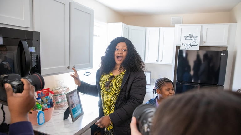 Homeowner Flora Ikuomenisan reacts after seeing her new kitchen at the...