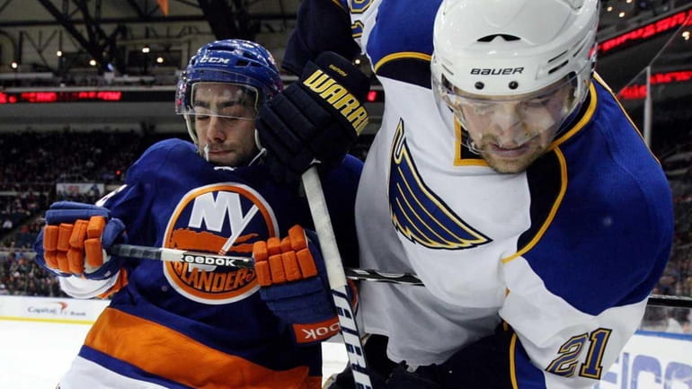 Matt Moulson #26 of the New York Islanders fights for...