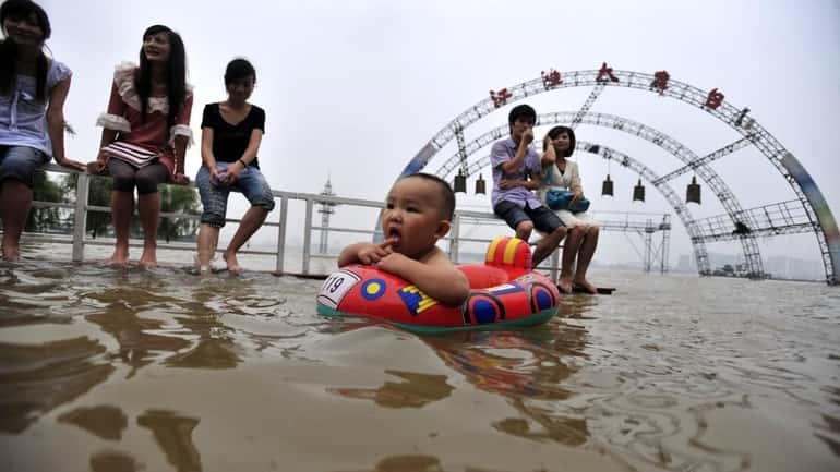 Residents enjoy the water along a flooded riverbank in Wuhan...