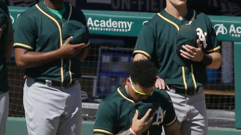 Oakland Athletics catcher Bruce Maxwell takes a knee during the...