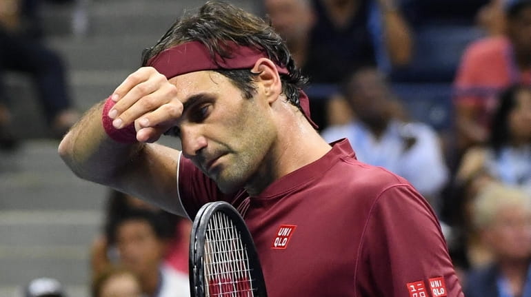 Roger Federer wipes sweat from his forehead during his match...