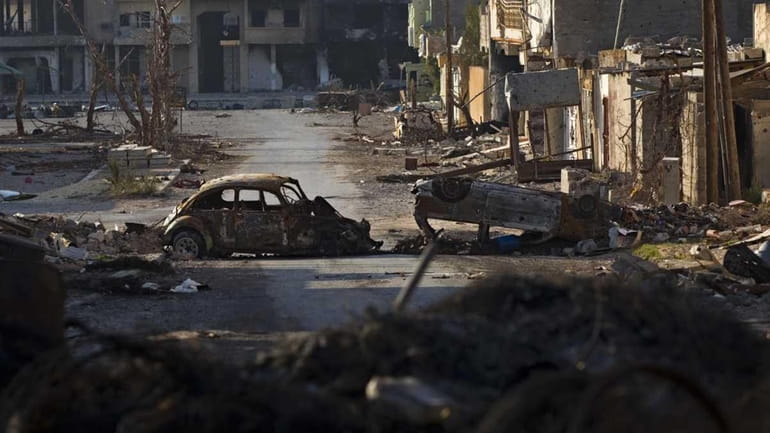 Destroyed cars and buildings are seen in the besieged city...
