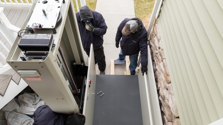 A crew from 101 Mobility installs a platform lift outside...