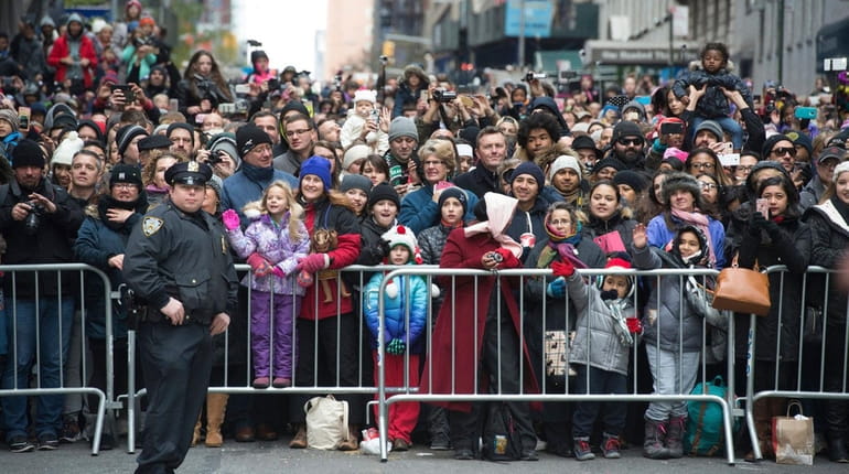 Crowds line the sidewalk and street during the Macy's Thanksgiving...