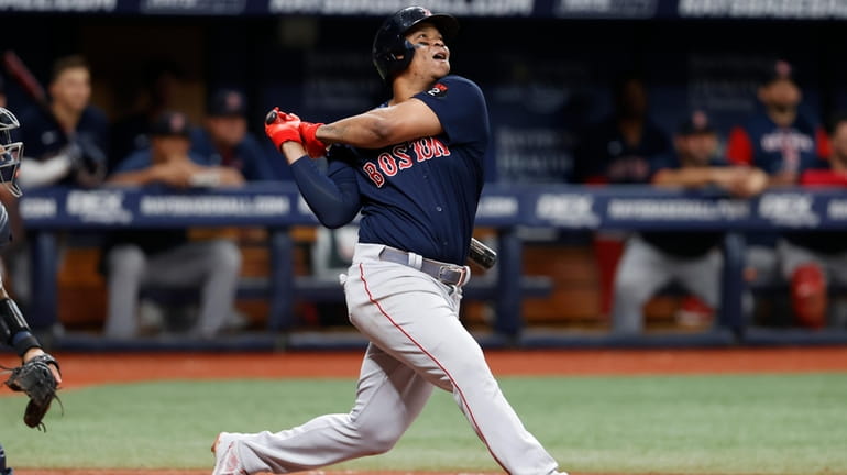 FILE - Boston Red Sox's Rafael Devers watches his RBI-single...