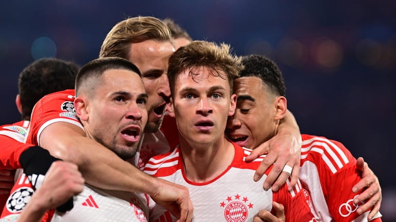 Bayern's Joshua Kimmich, centre, celebrates with teammates after scoring his...