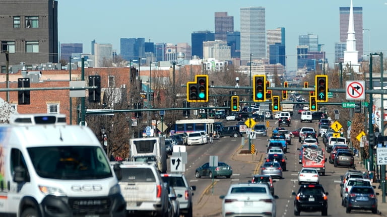 Motorists move northbound along South Broadway as the skyline of...