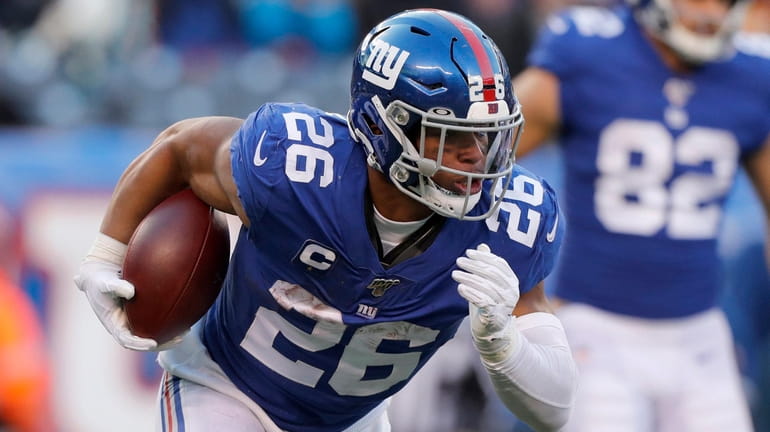 Saquon Barkley of the Giants runs the ball during the fourth...