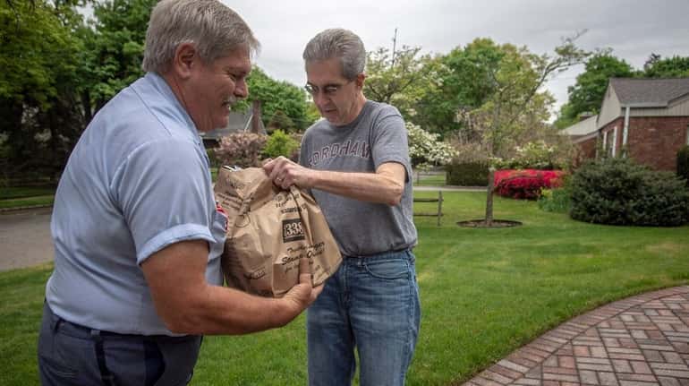Mail carrier Rich Lepis picks up food donated by Chris...