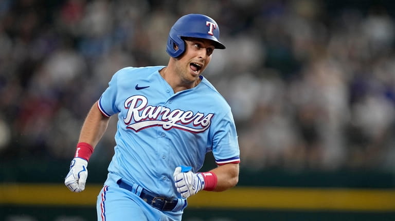 Texas Rangers' Nathaniel Lowe sprints home to score on a...