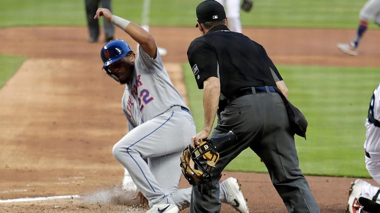 The Mets' Dominic Smith scores on a ground out by Juan...