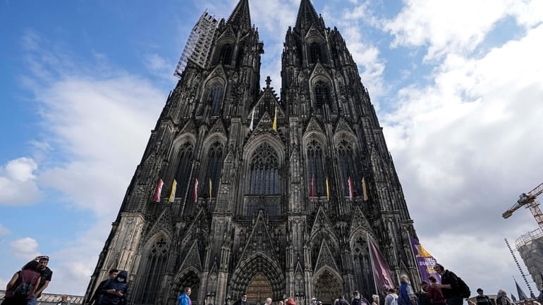 People line up in front of the Cologne Cathedral for...