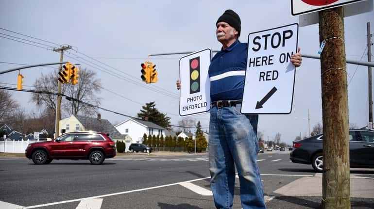 Andy Kuzma of Levittown holds signs required to be put up in...