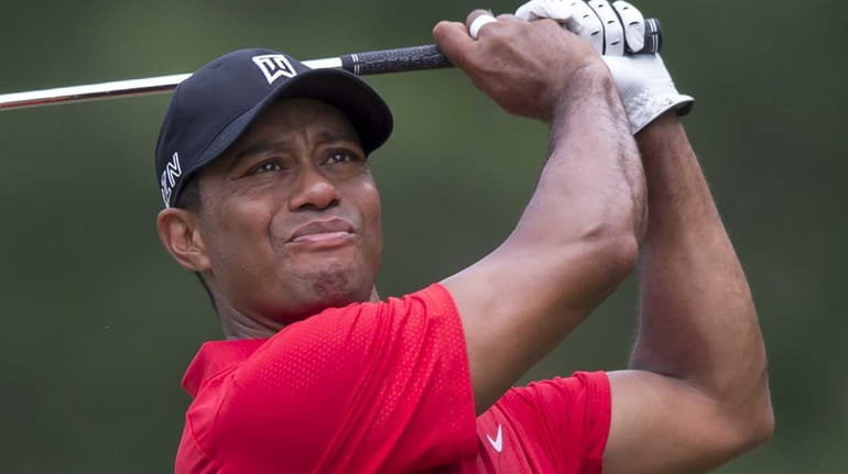 Tiger Woods watches his shot from the third tee during...