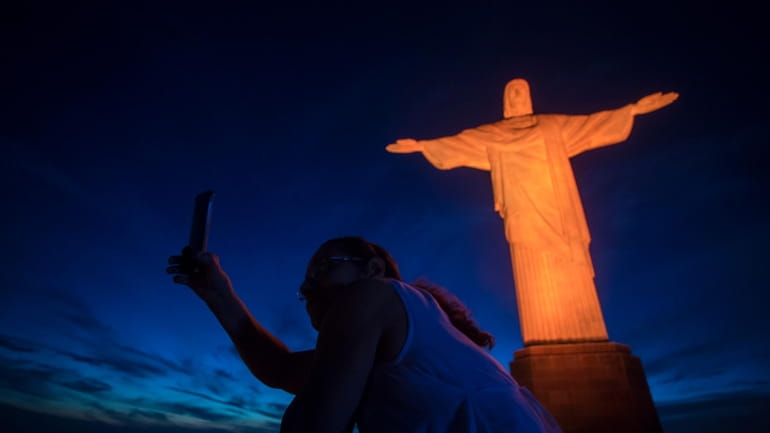 A tourist takes a selfie with the Christ the Redeemer...