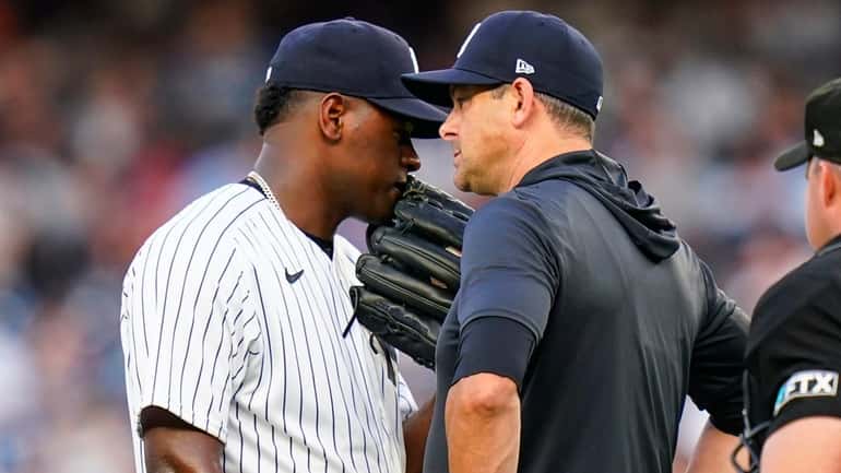 Yankees starting pitcher Luis Severino, left, talks to manager Aaron...