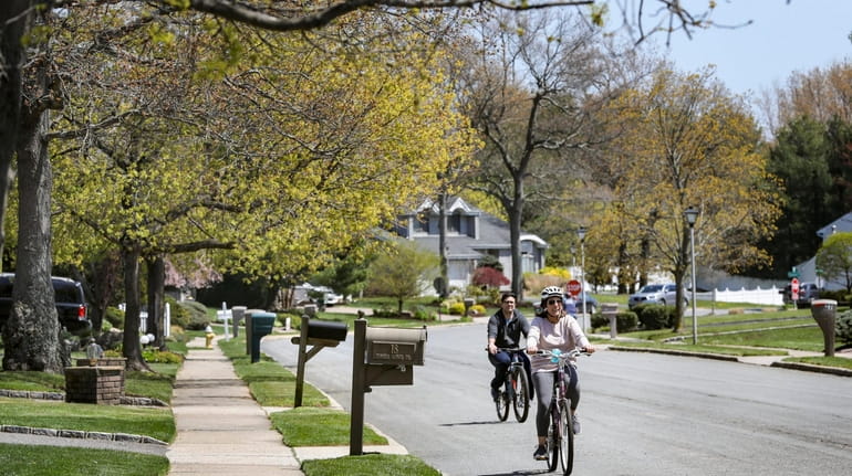 Bicyclists roll down the Country Woods section of Commack on...