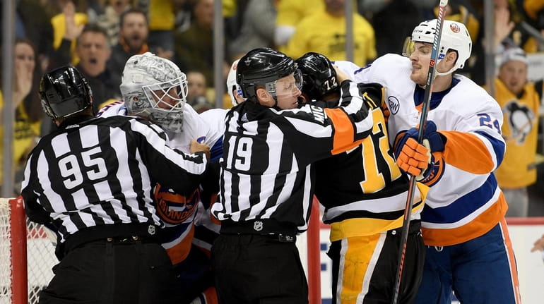 Robin Lehner of the Islanders exchanges punches with Patric Hornqvist...