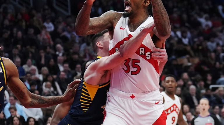 Toronto Raptors center Malik Williams (35) is wrapped up by...