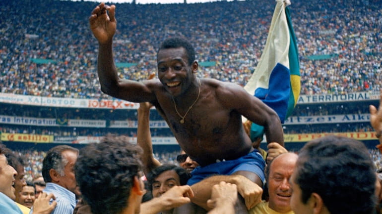 Pelé is hoisted on the shoulders of his teammates after Brazil...