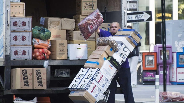 A worker unloads grocery goods in Washington, D.C., on Nov....