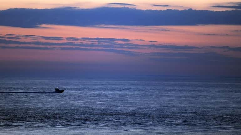 A fishing boat cruising during the early morning hour just...
