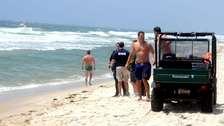 Lifeguards and emergency workers organize the search for a missing...