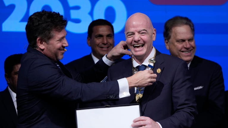 Conmebol President Alejandro Dominguez, left, honors FIFA President Giovanni Infantino...