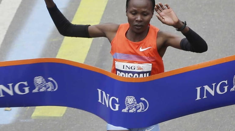 Priscah Jeptoo of Kenya crosses the finish line first in...