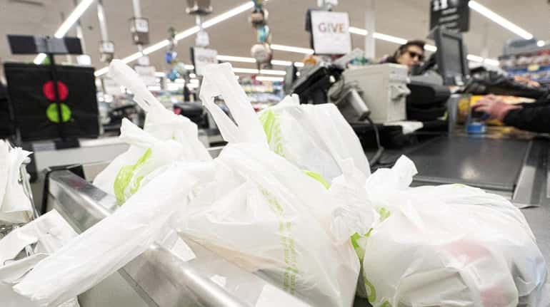 A customer uses plastic bags at Stop and Shop in...