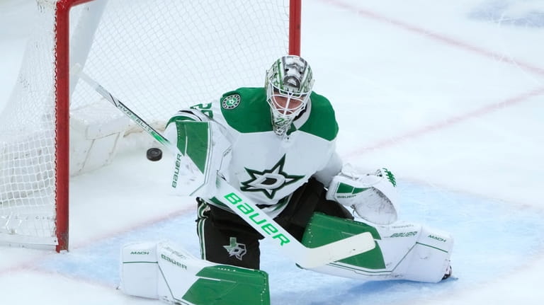 Dallas Stars goaltender Jake Oettinger deflects the puck during the...