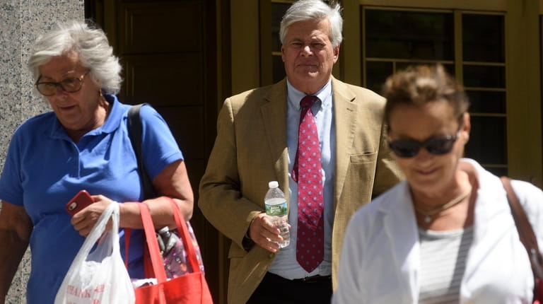 Dean Skelos, center, exits a federal courthouse in Manhattan during...