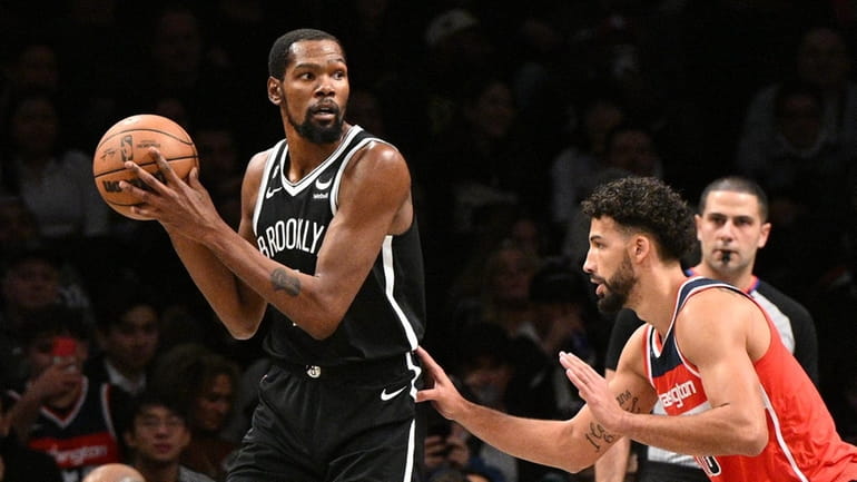 Nets forward Kevin Durant is defended by Washington Wizards forward...
