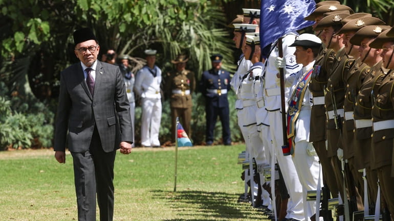 The Prime Minister of Malaysia Anwar Ibrahim inspects a guard...