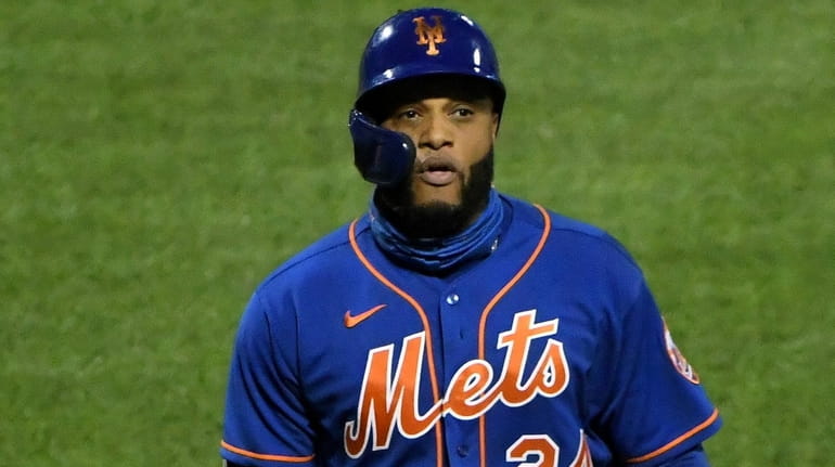 Mets designated hitter Robinson Cano returns to the dugout after...