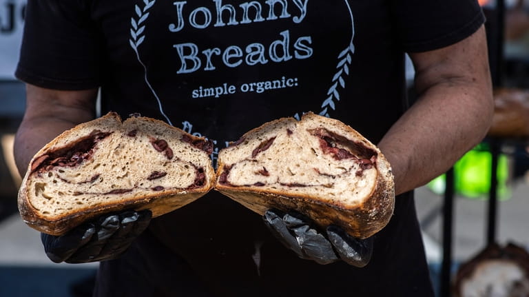 John DellAquila, of Johnny Breads, holds up a olive sourdough...