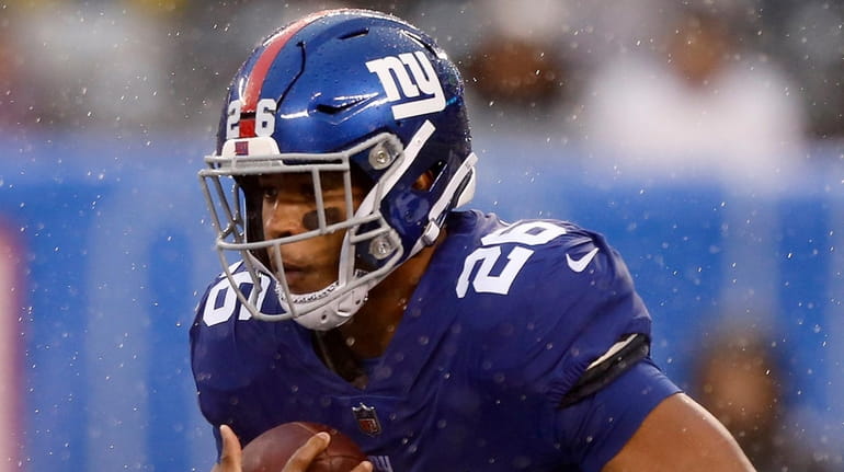The Giants' Saquon Barkley runs the ball during the second...