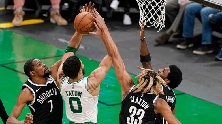 Boston Celtics forward Jayson Tatum (0) has his shot blocked...